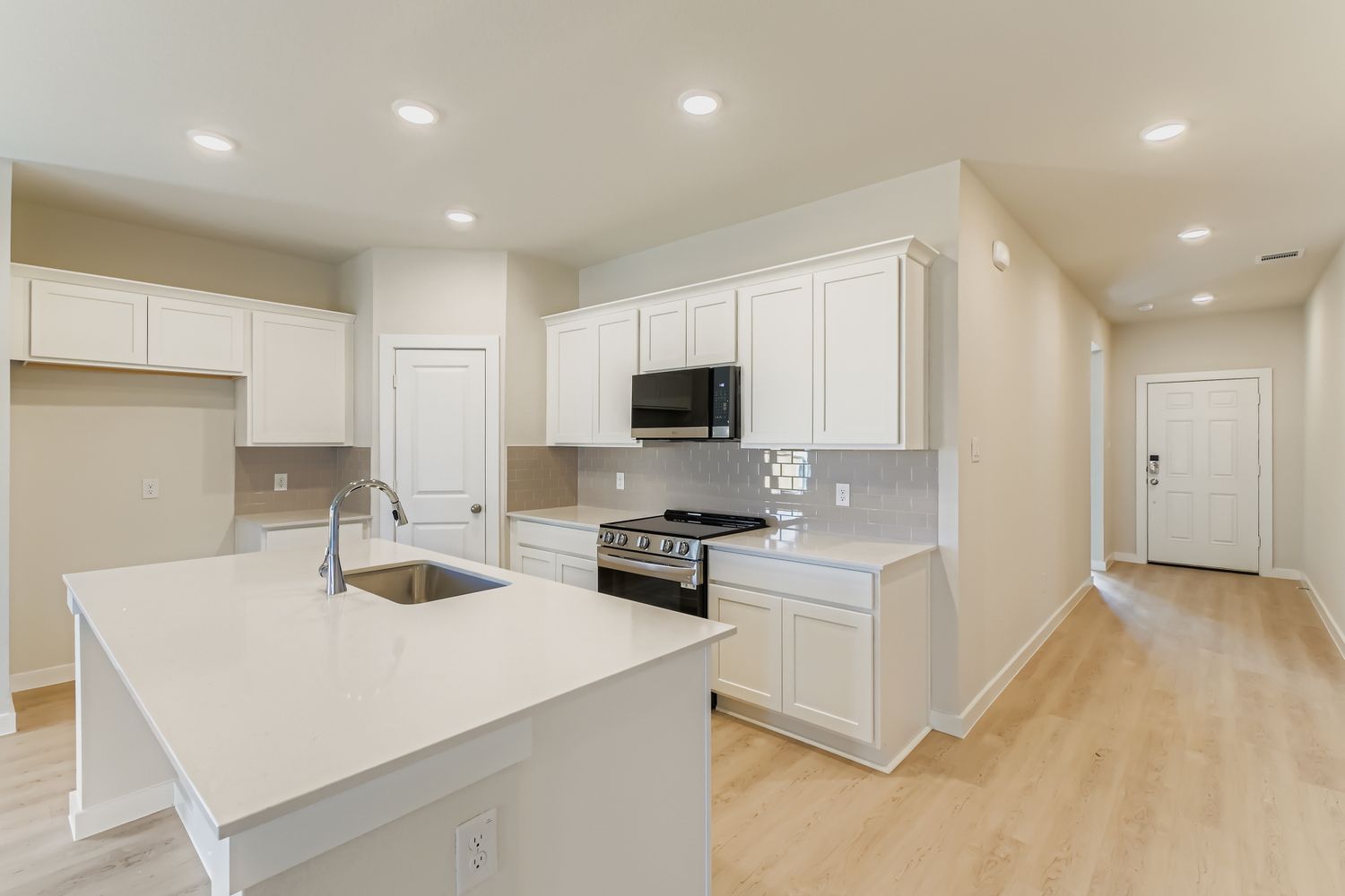 A kitchen with white cabinets.