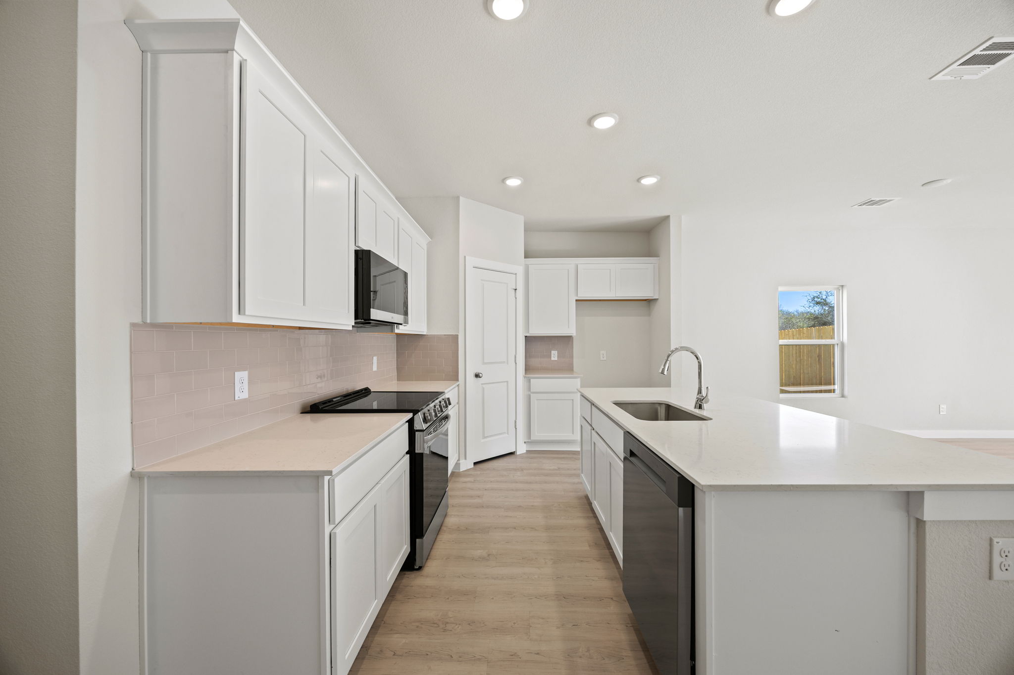A kitchen with white cabinets.