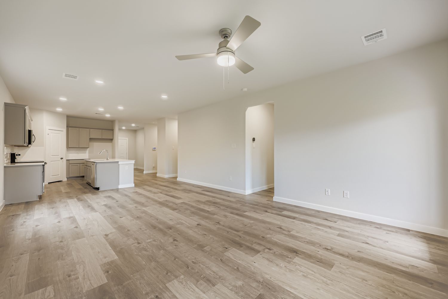 A room with a wood floor and a ceiling fan.