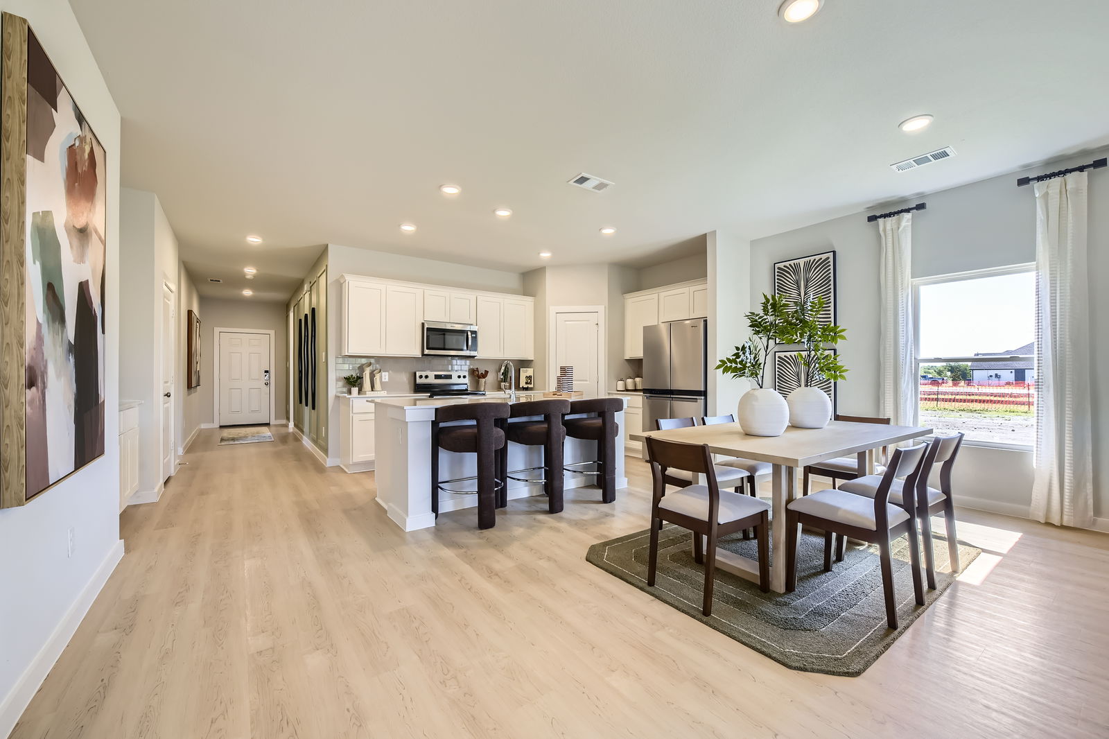 A kitchen with a dining table and chairs.