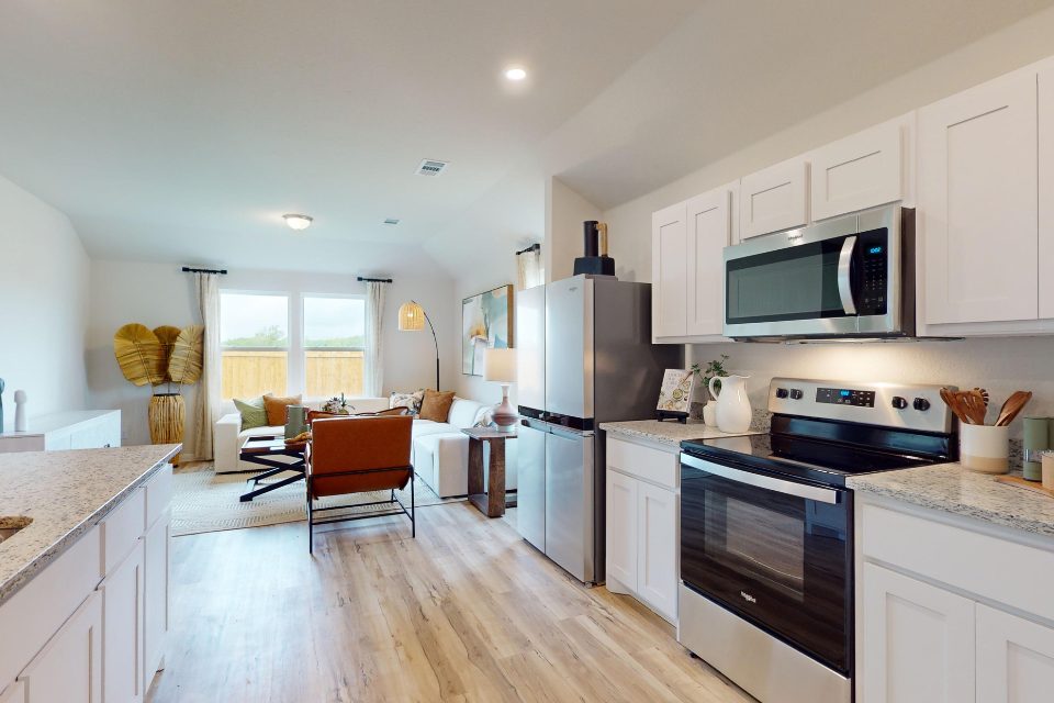 A kitchen with white cabinets.