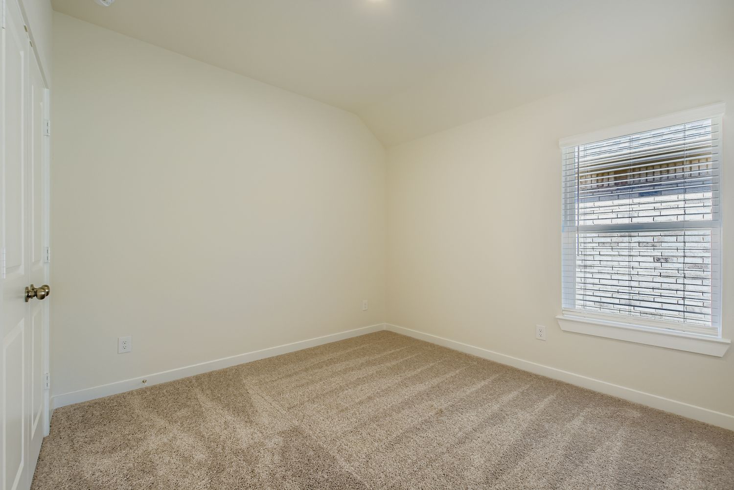 A room with a window and a carpet.