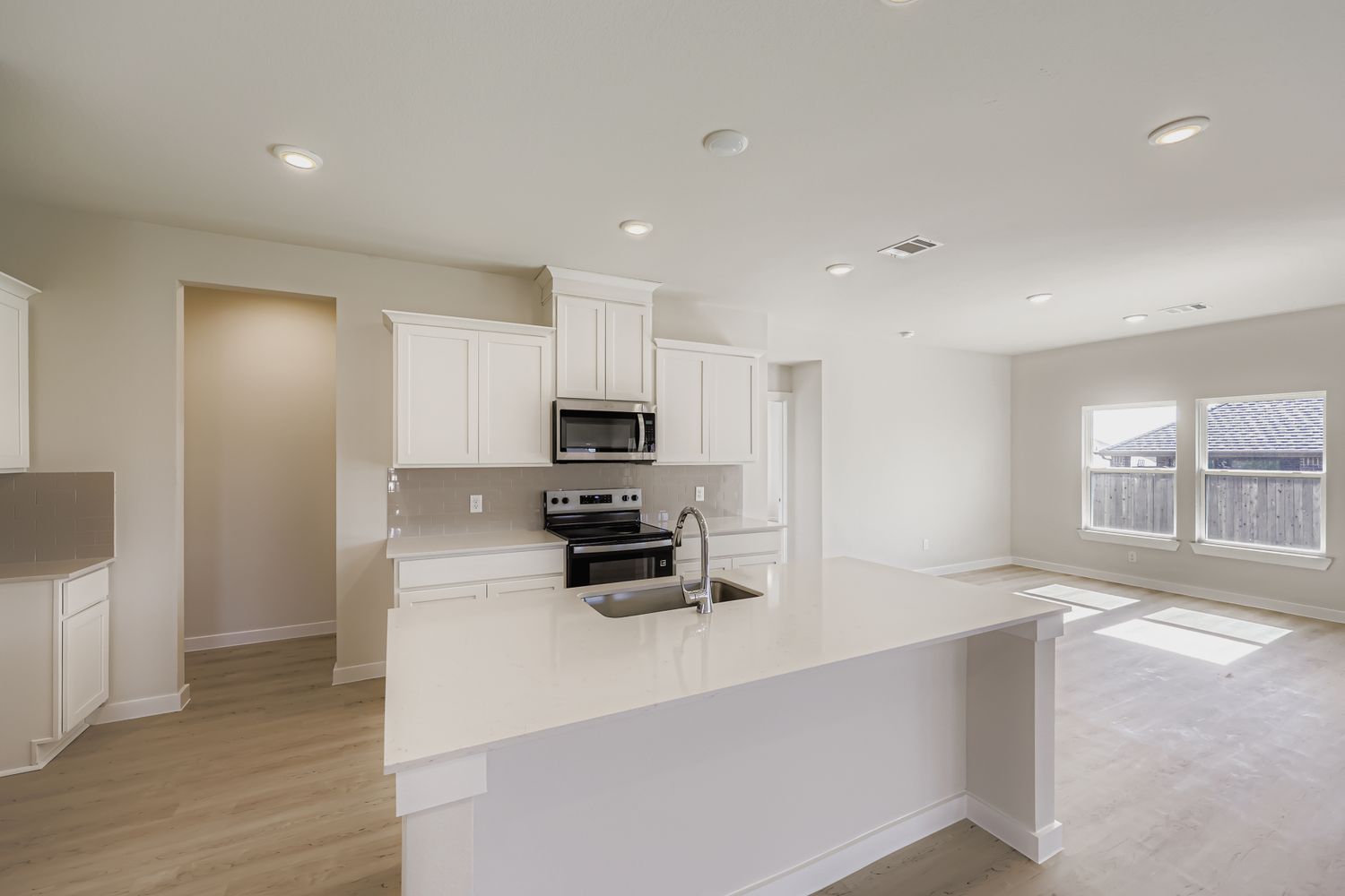 A kitchen with white cabinets.