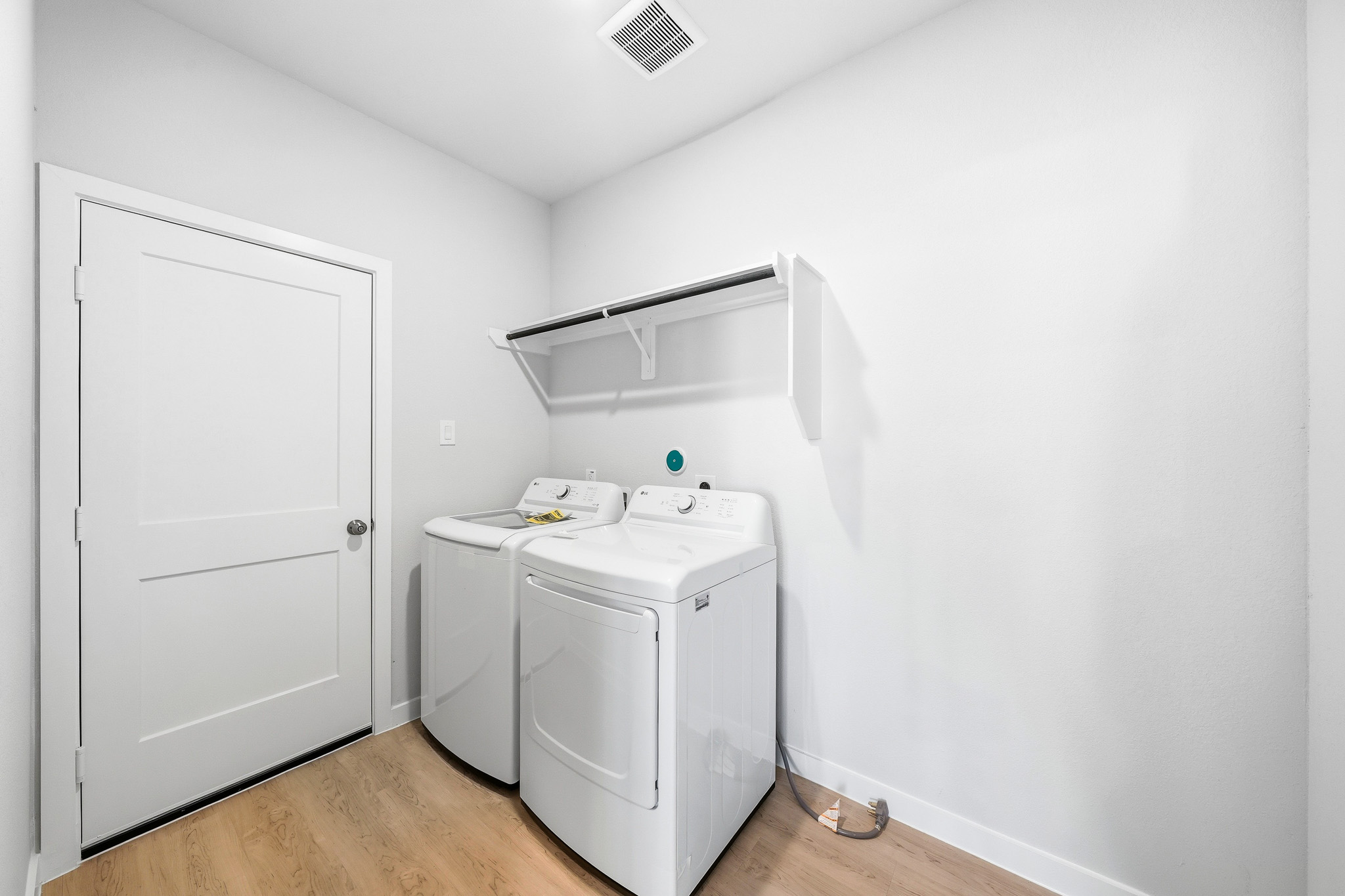A white laundry room with a white door and a white door.