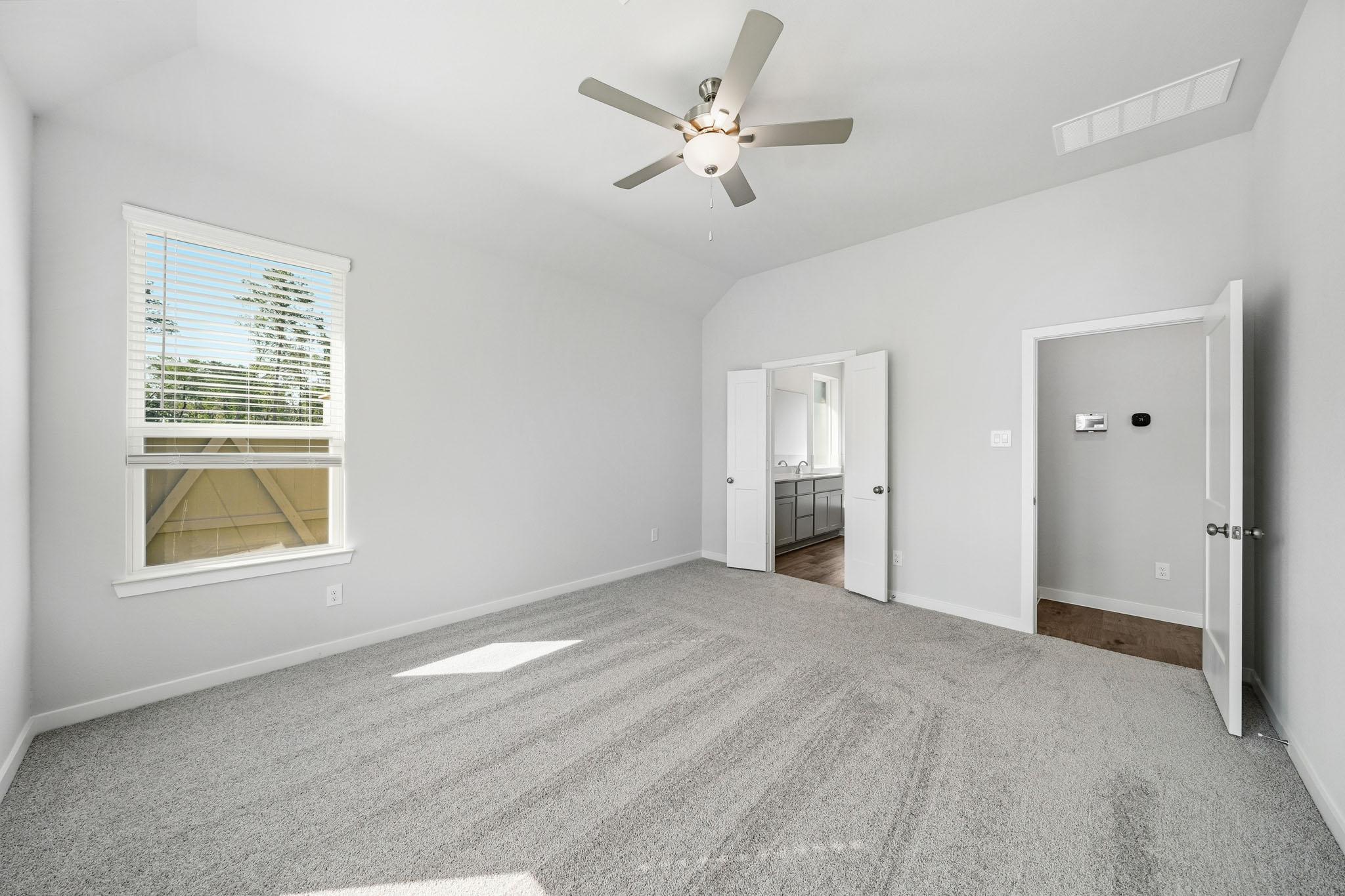 A room with a ceiling fan and a window.