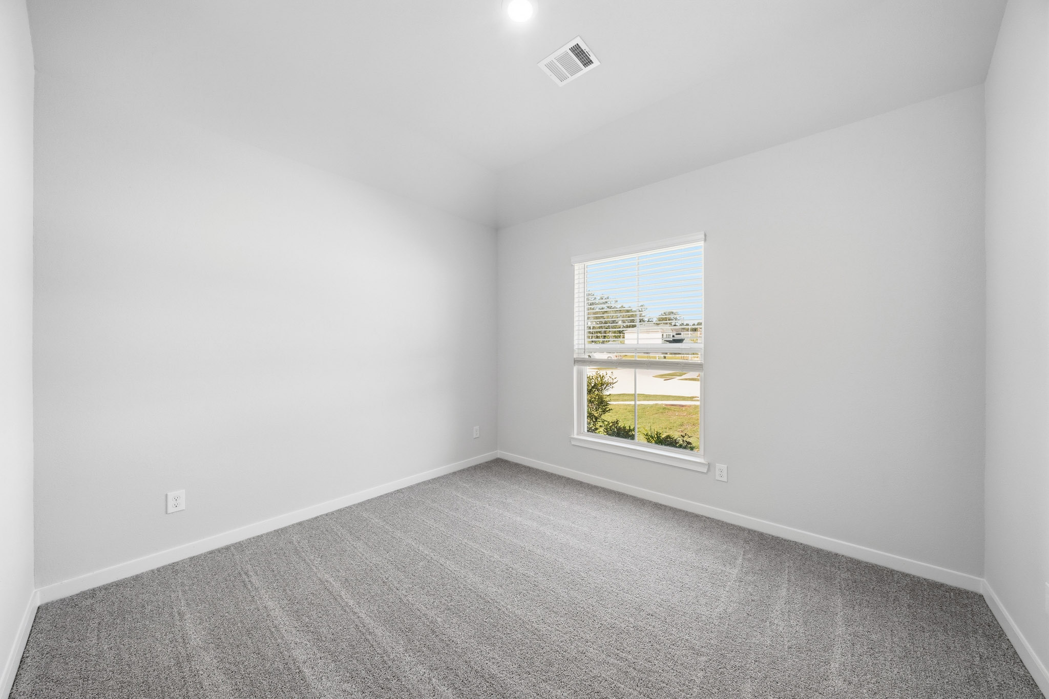 A room with a window and a carpet.