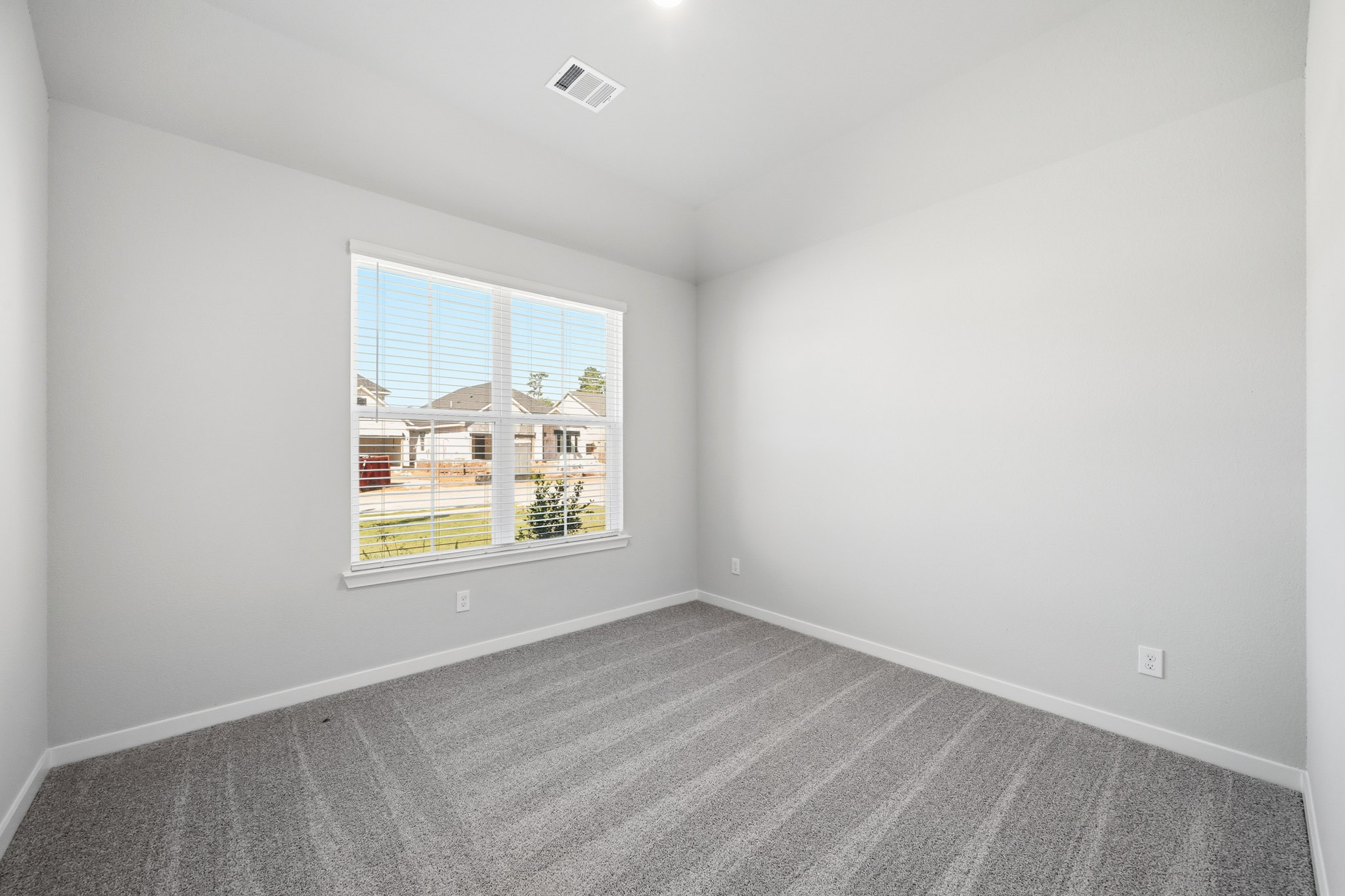 A room with a window and a carpet.