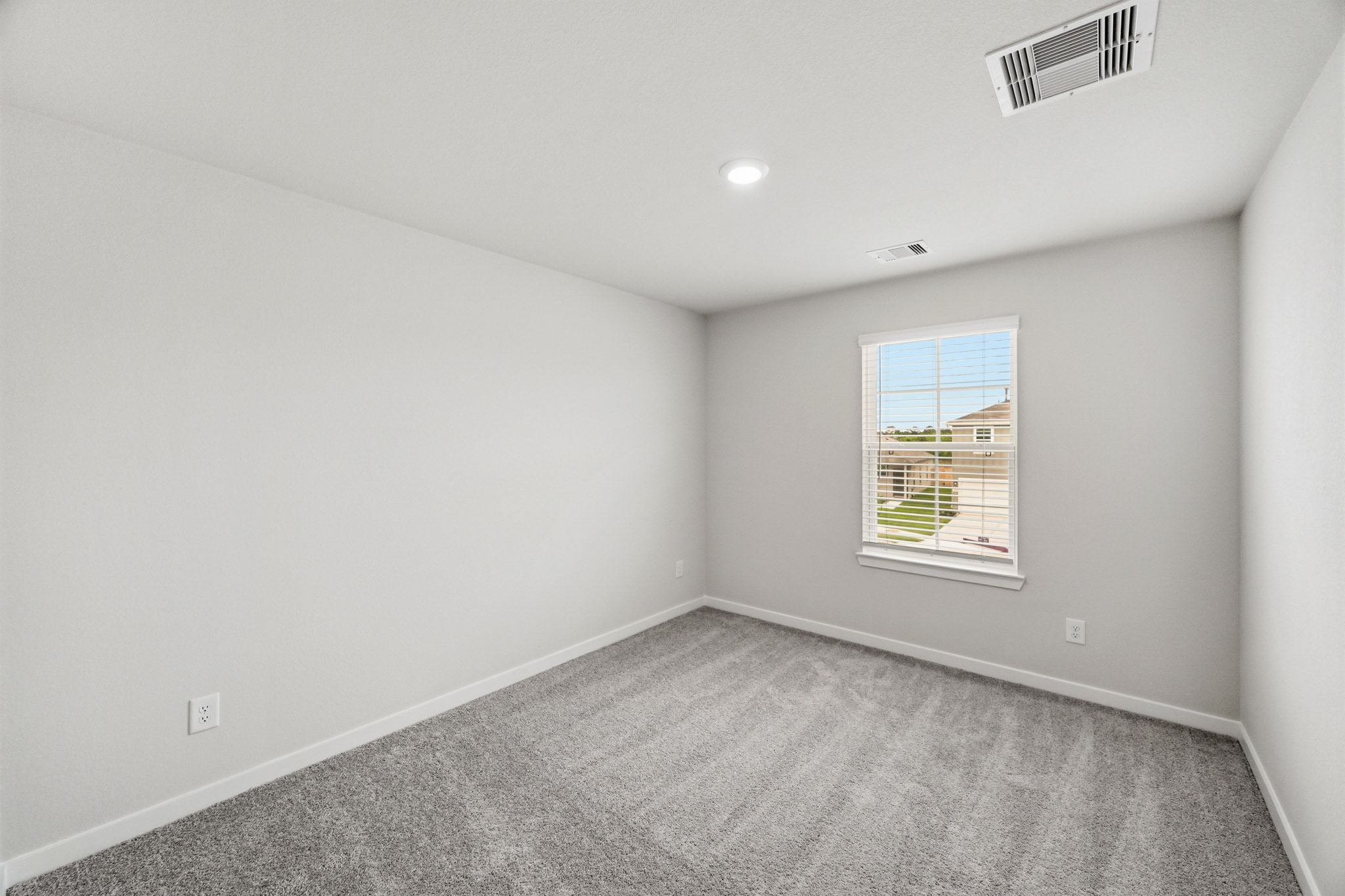 A room with a window and a carpet.