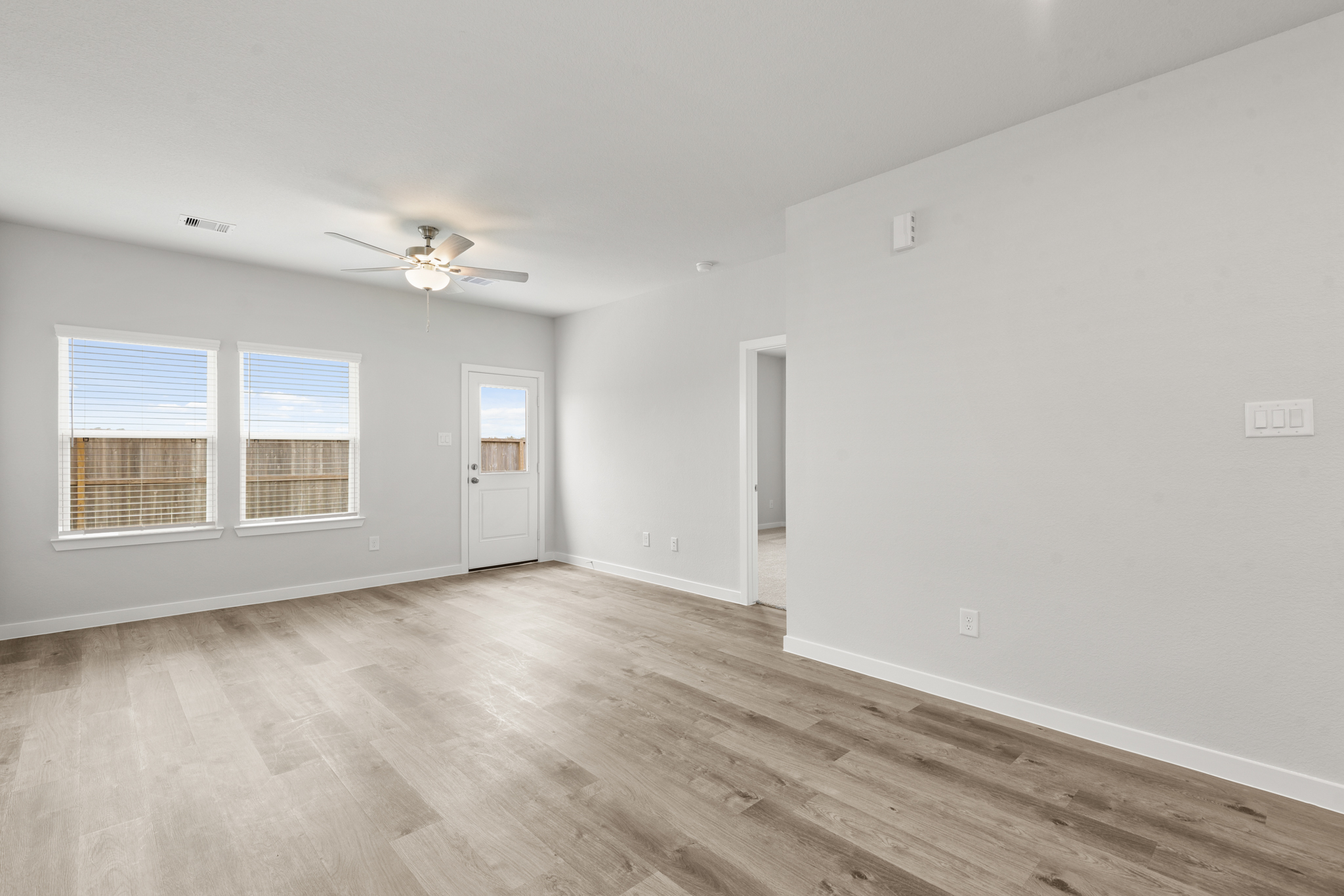 A room with a wood floor and a ceiling fan.