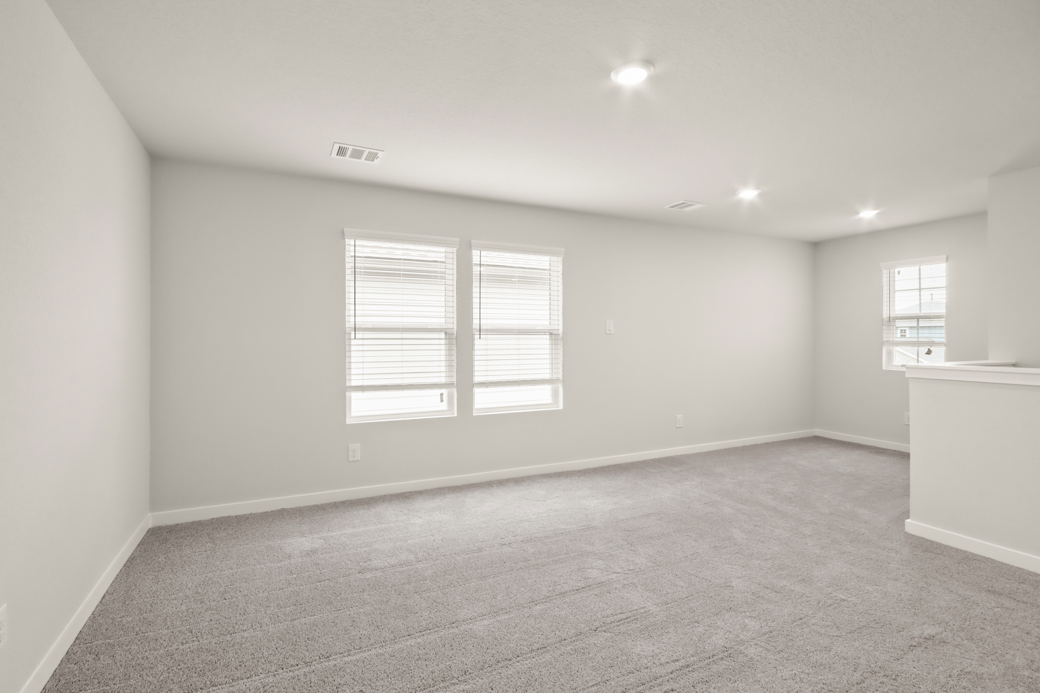 A room with a white wall and windows.