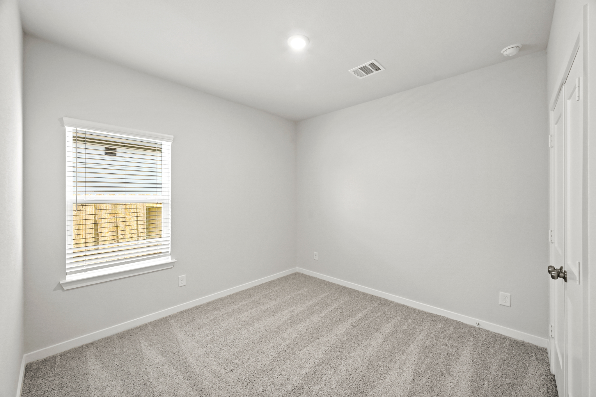 A room with a carpet and a window.