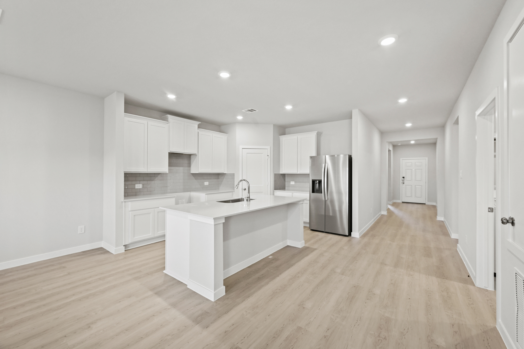 A kitchen with white cabinets.