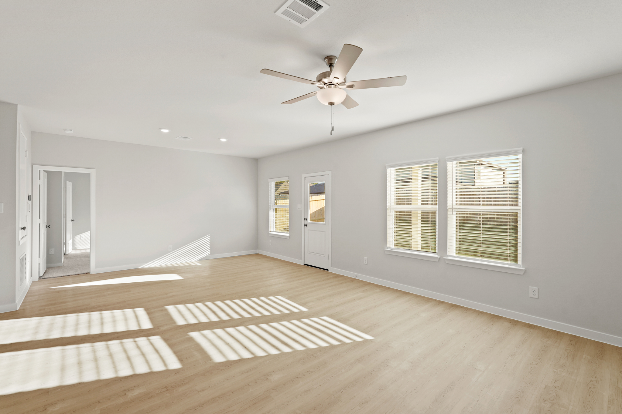 A room with a wood floor and a ceiling fan.