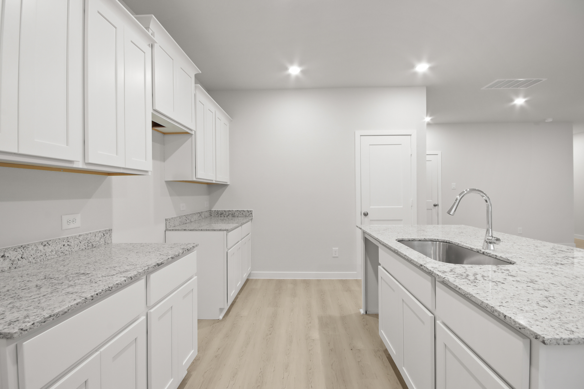 A kitchen with white cabinets.