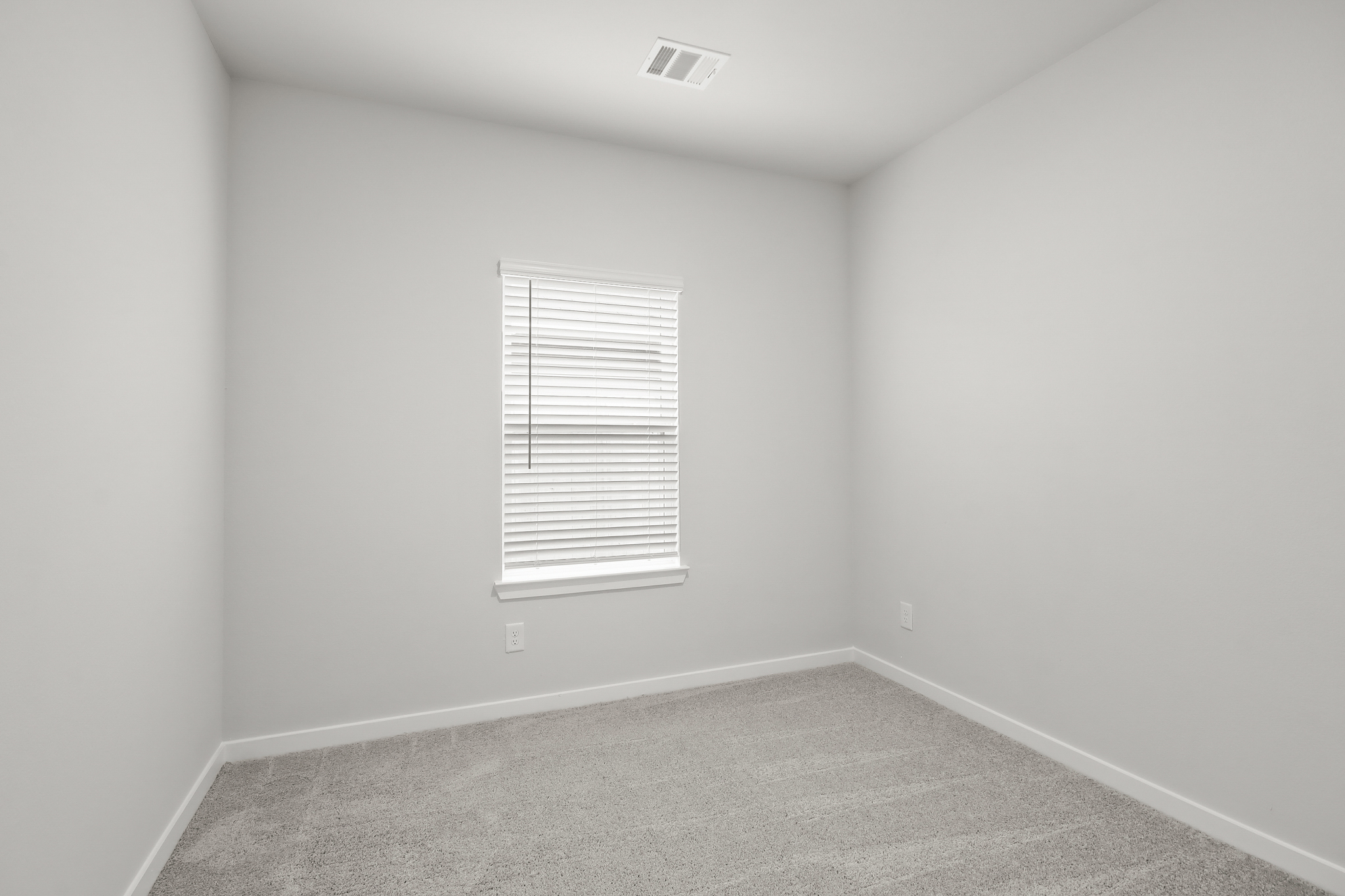 A room with a window and a carpet.