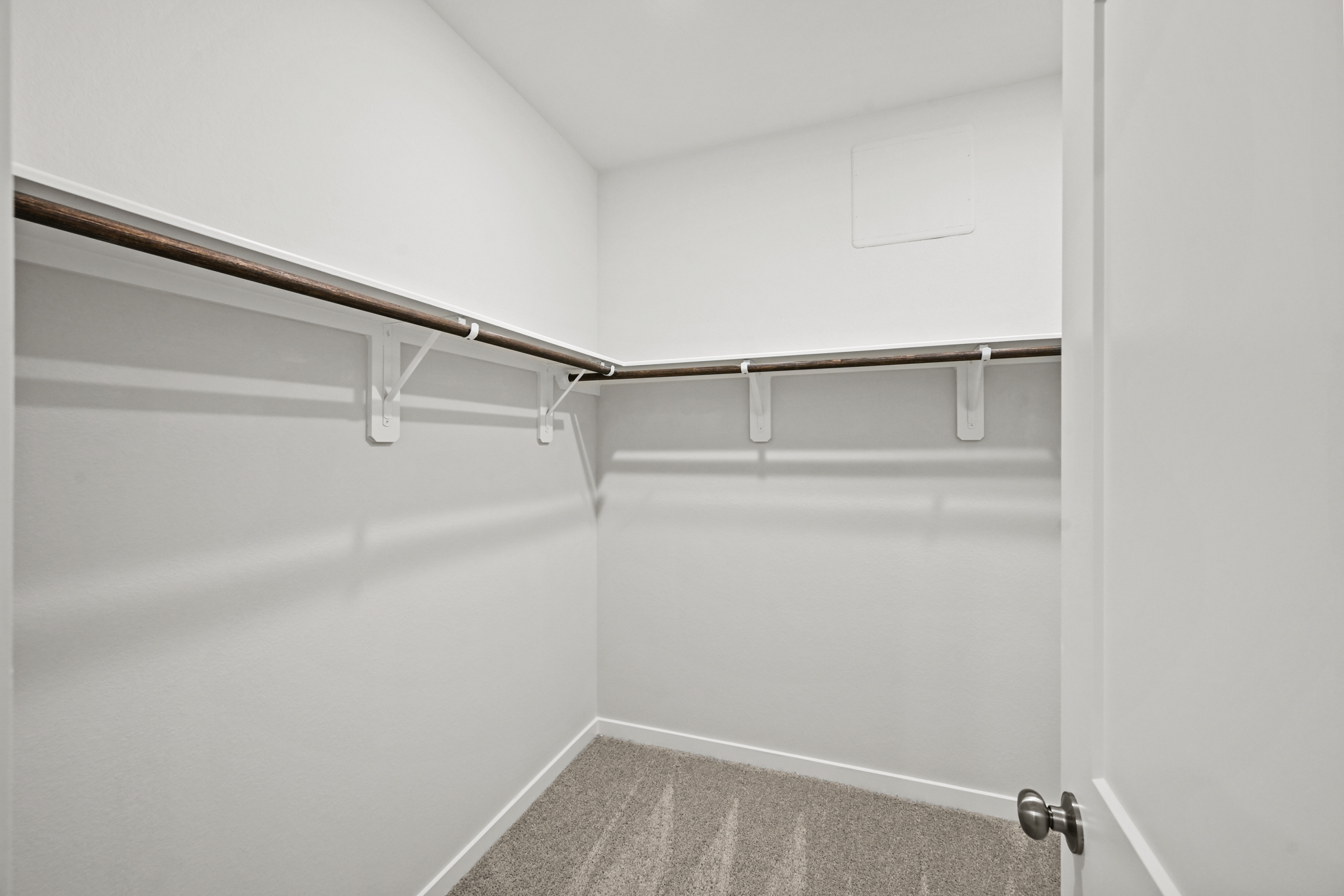 A white wall with a metal bar.