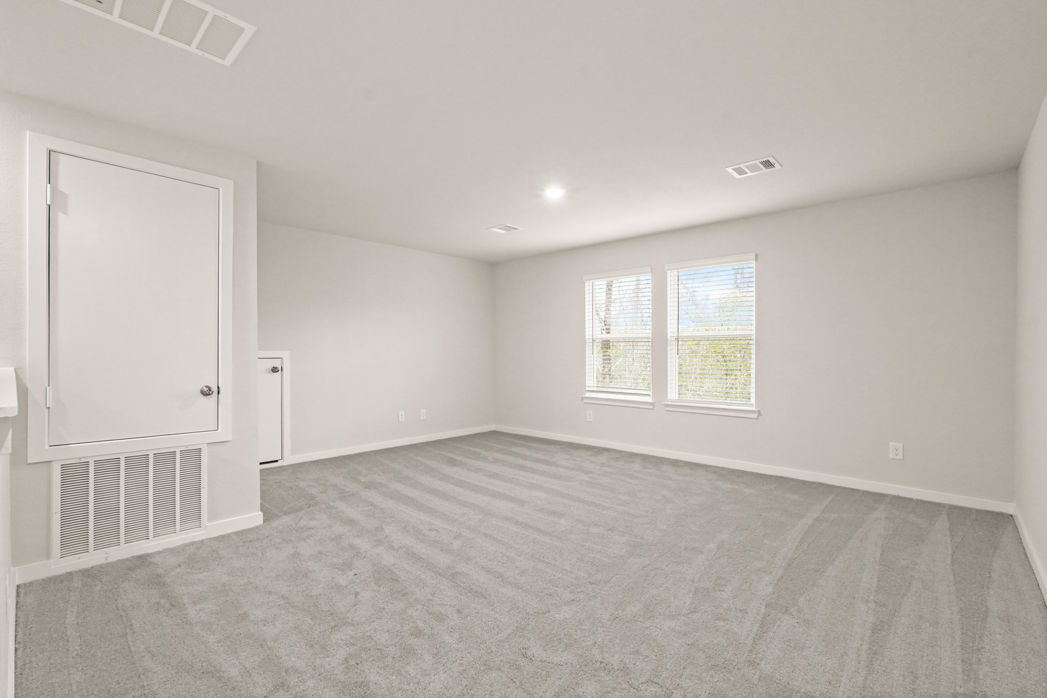 A room with a carpet and a window.