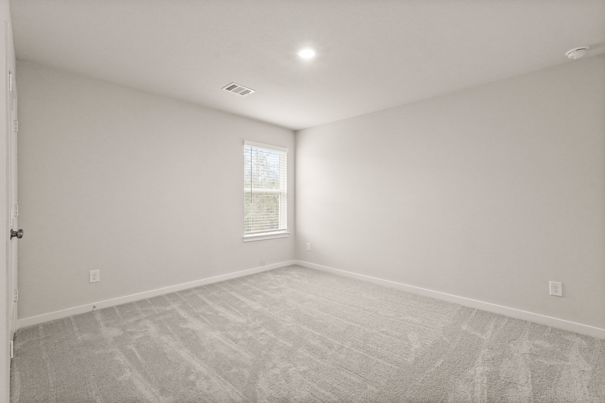 A room with a window and a carpet.