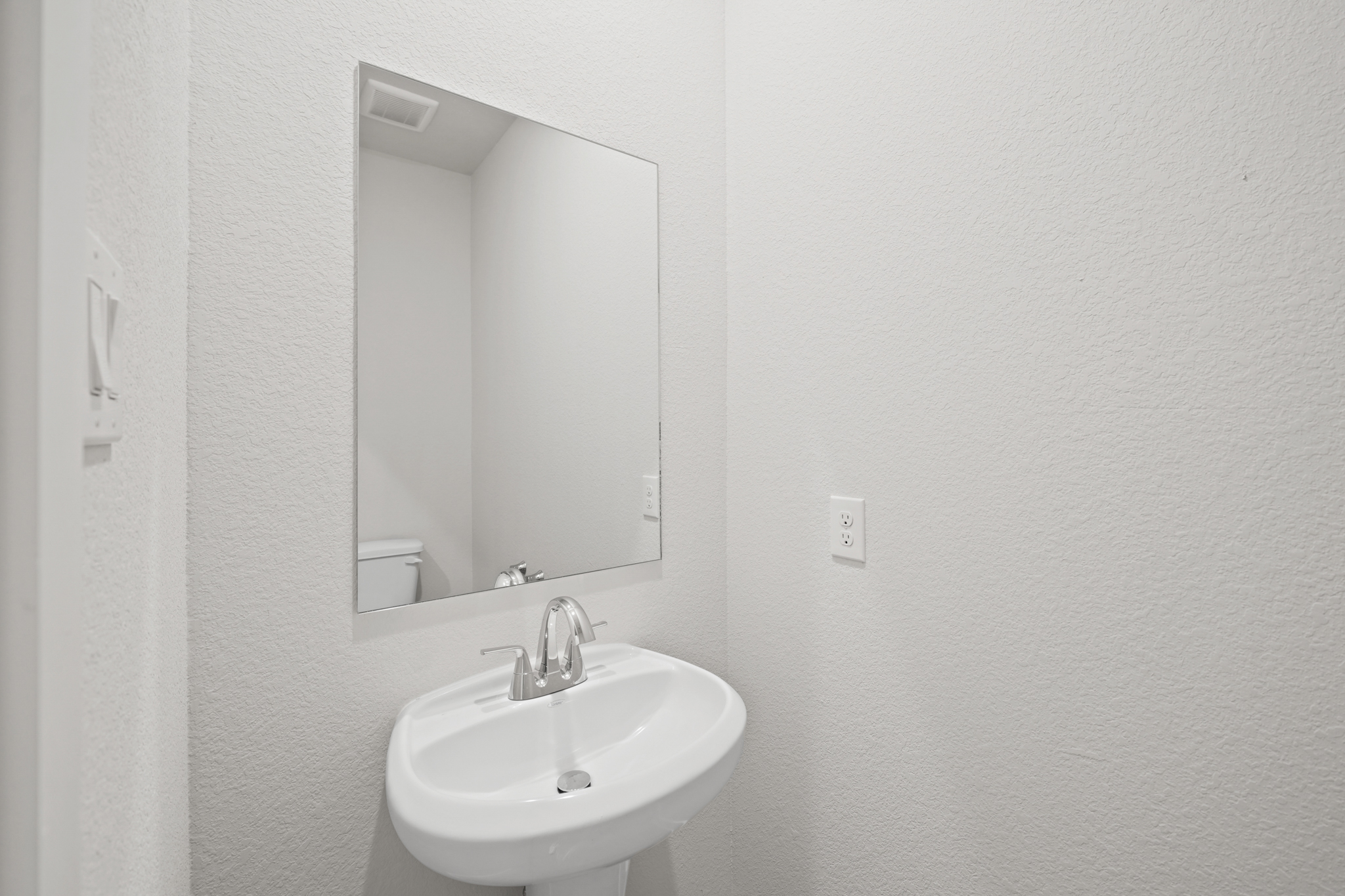 A bathroom with a mirror and sink.