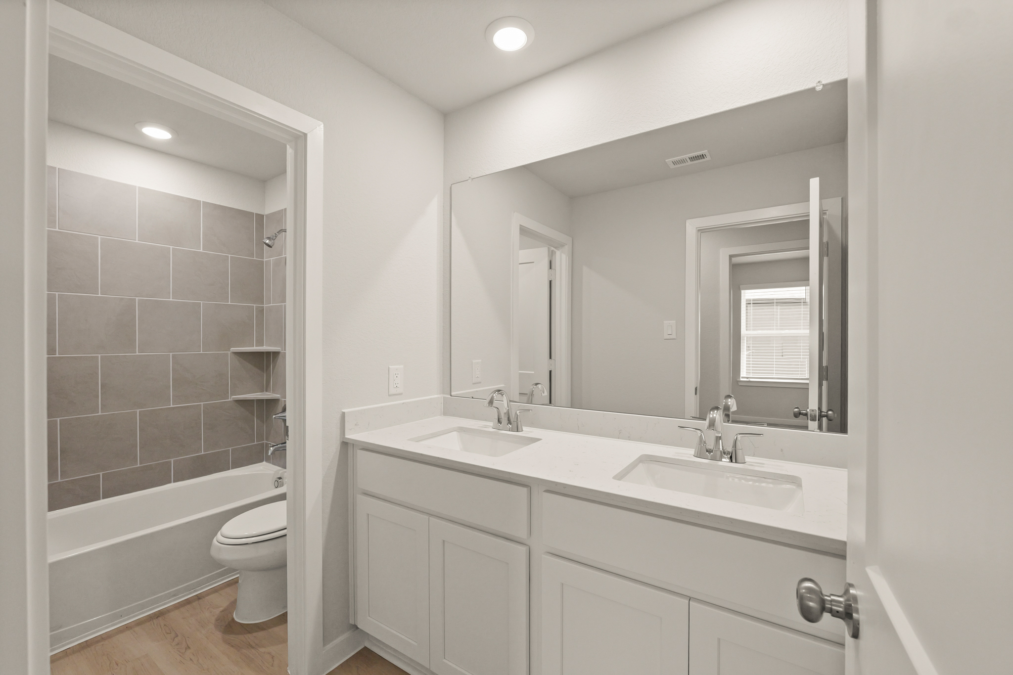 A bathroom with a large mirror.