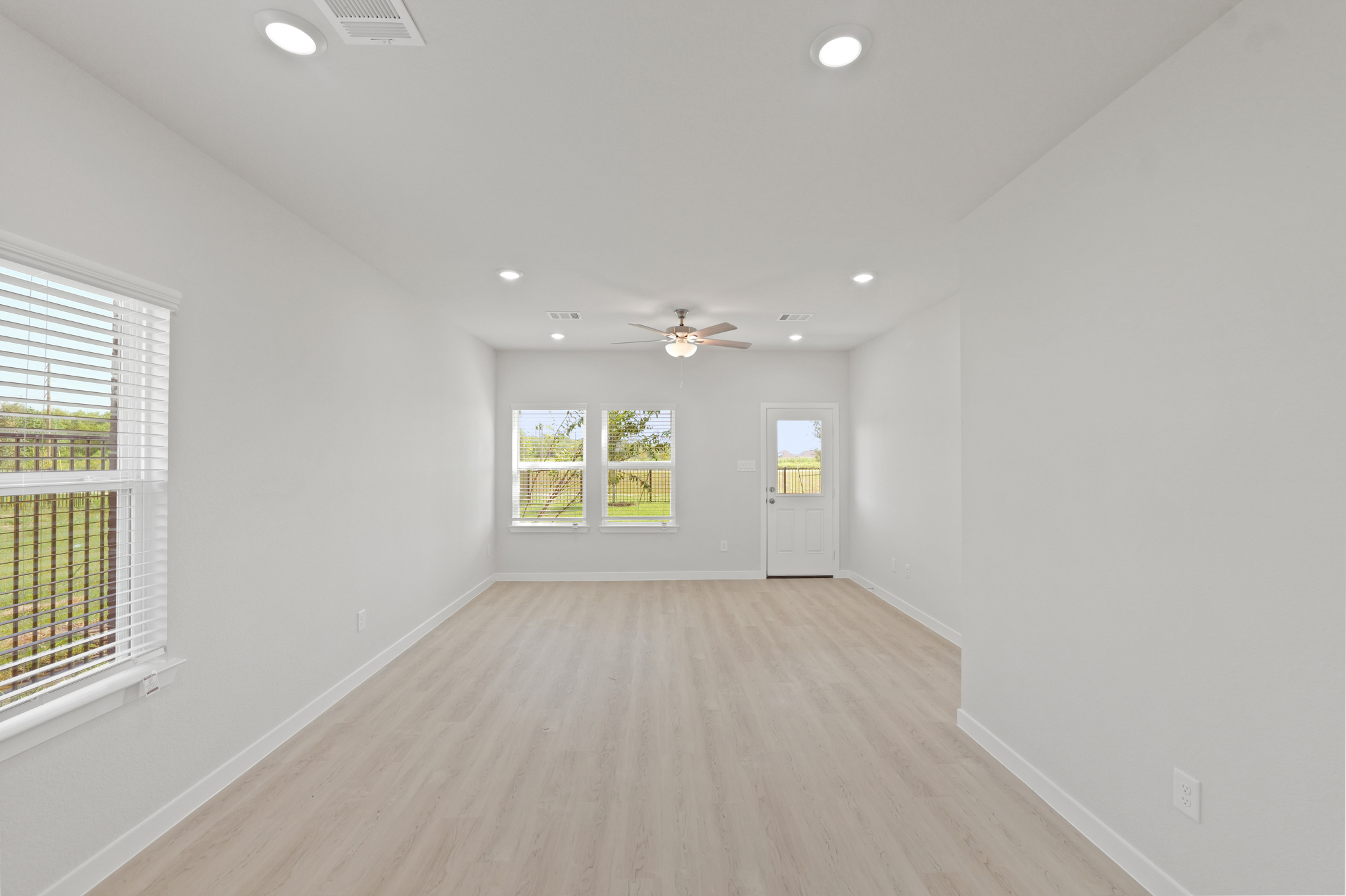 A room with a wood floor and windows.