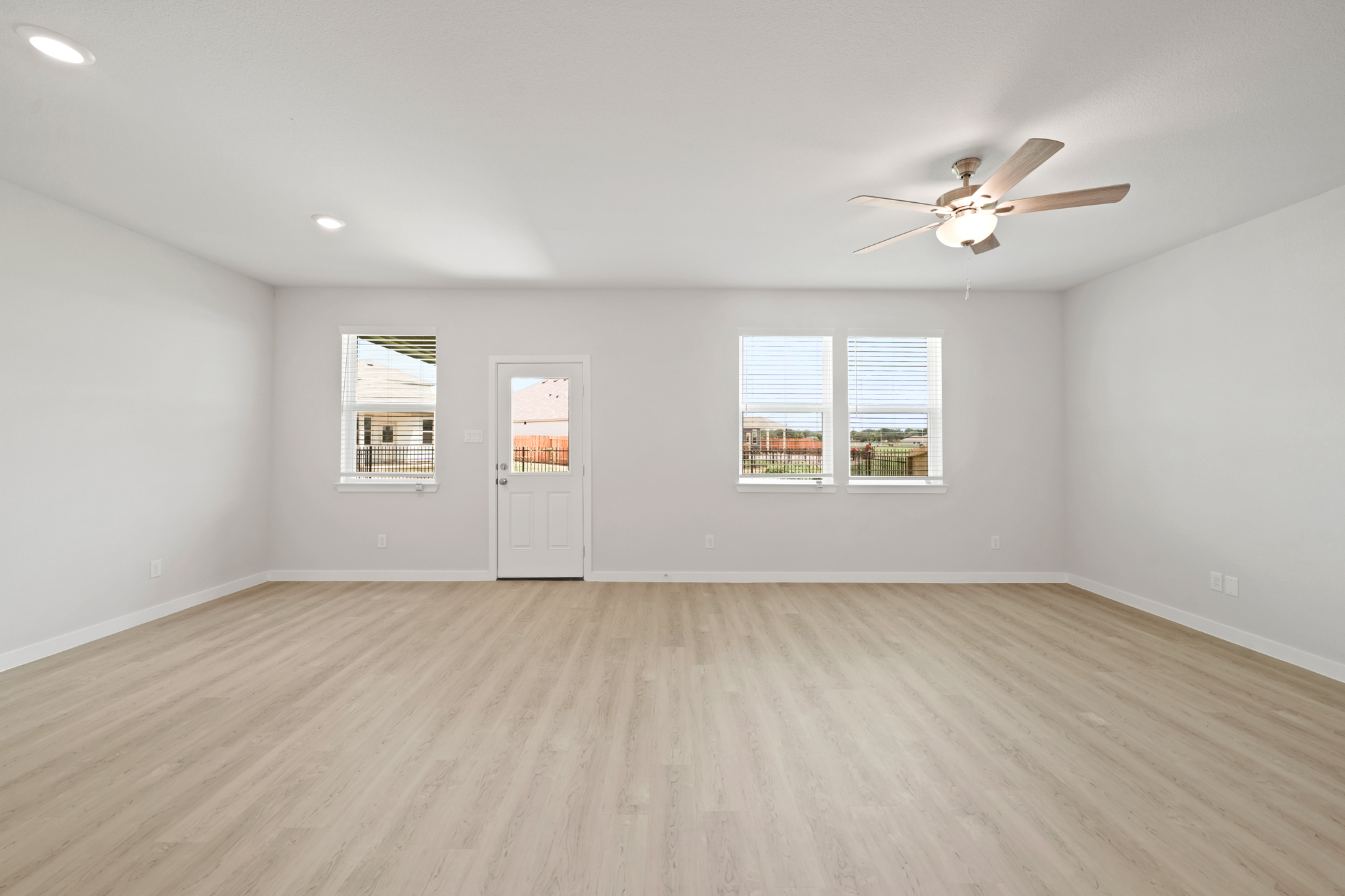 A room with a wood floor and a ceiling fan.