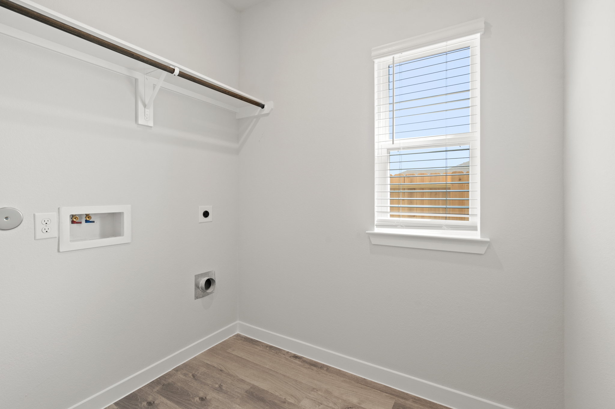 A room with a window and a wood floor.