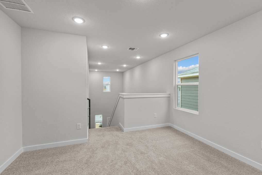 A room with a white wall and a window.