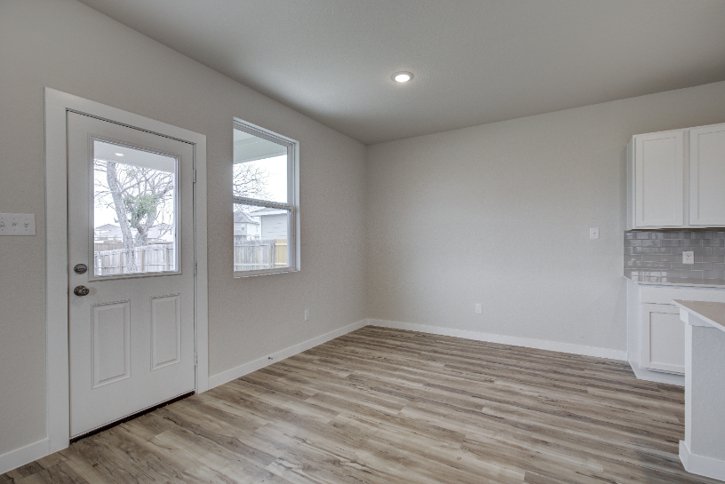 A room with a wood floor and a white door.