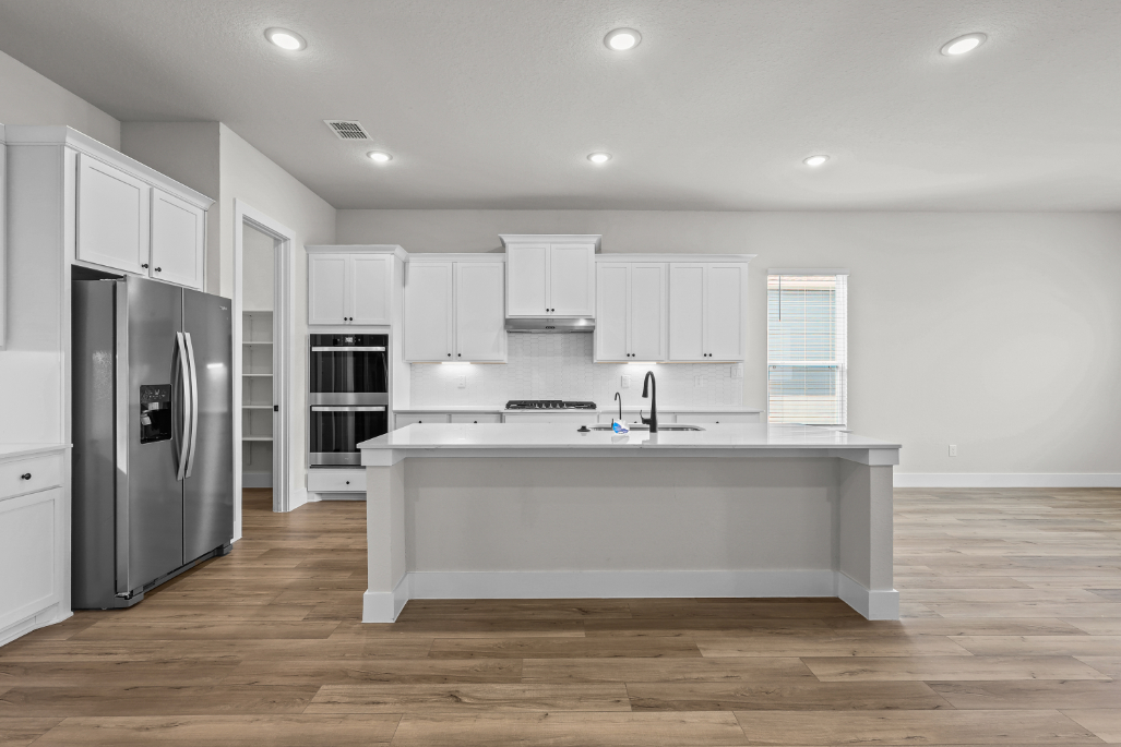 A kitchen with white cabinets.