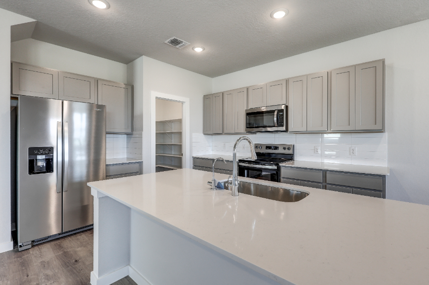 A kitchen with white cabinets.