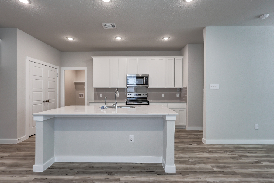 A kitchen with white cabinets.