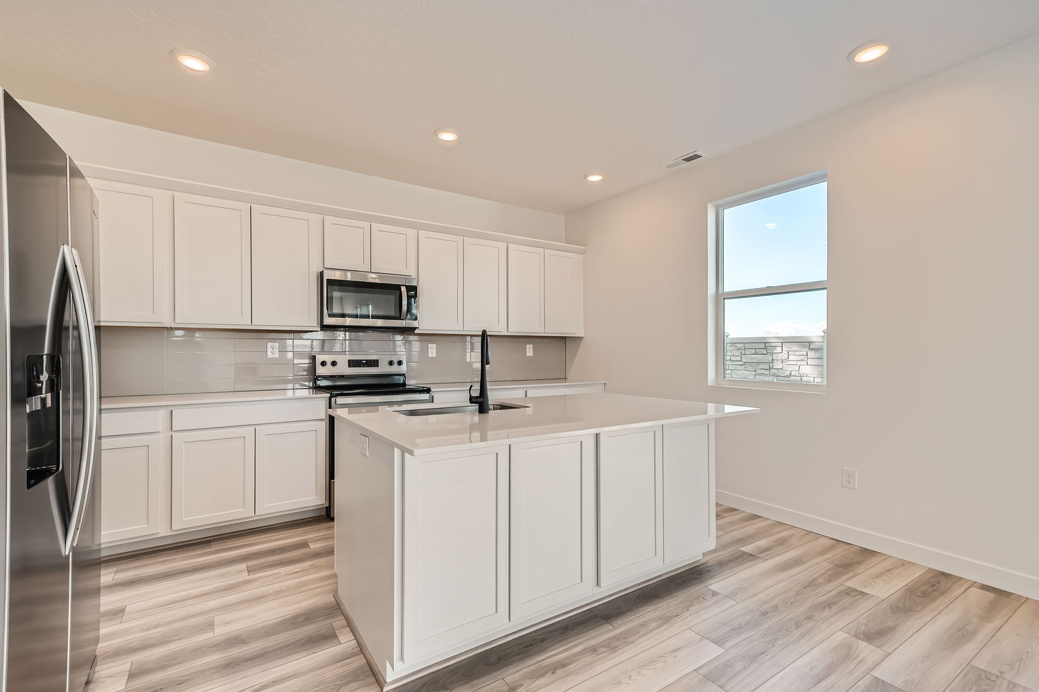 A kitchen with white cabinets.