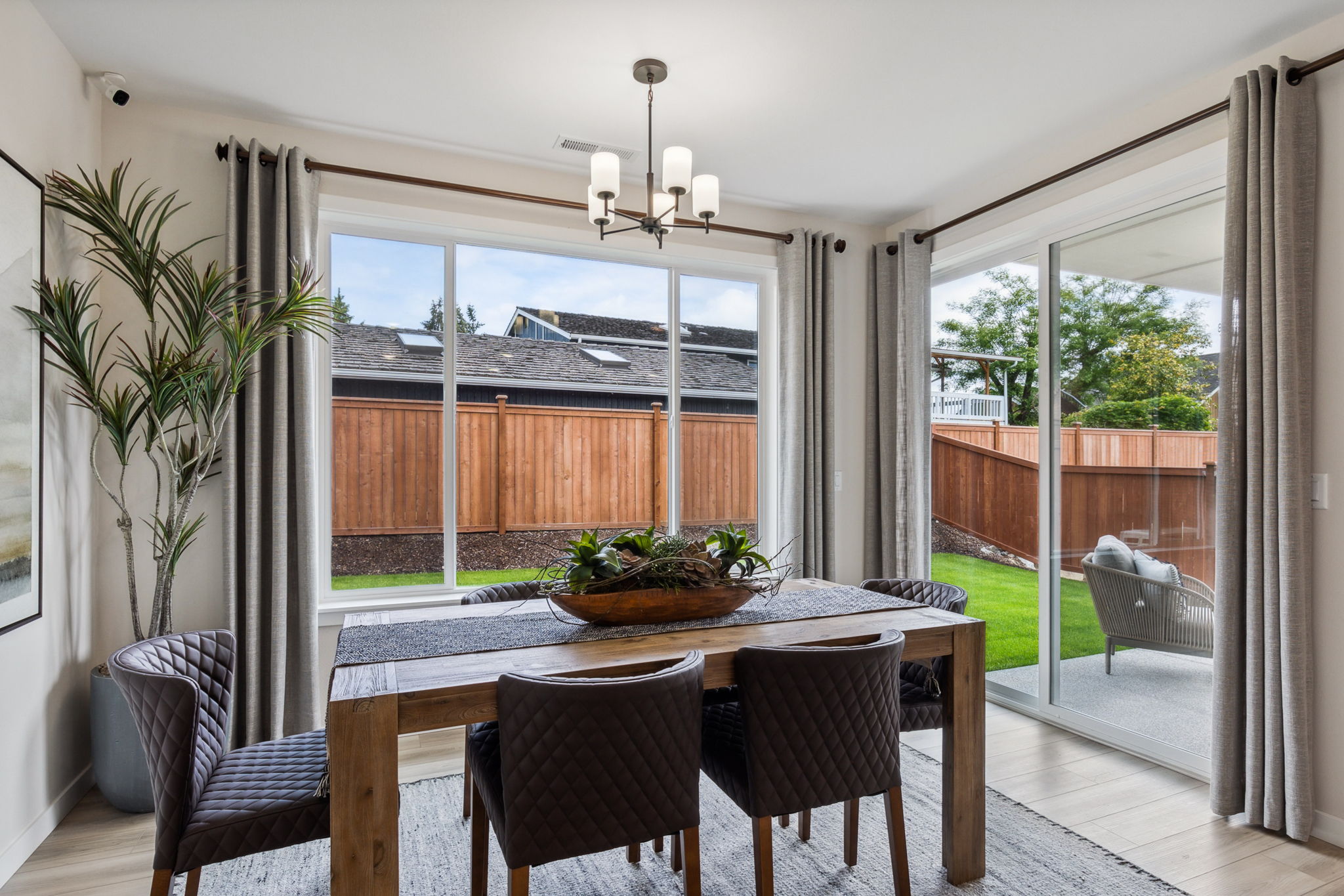 A dining room table with chairs and a large window.
