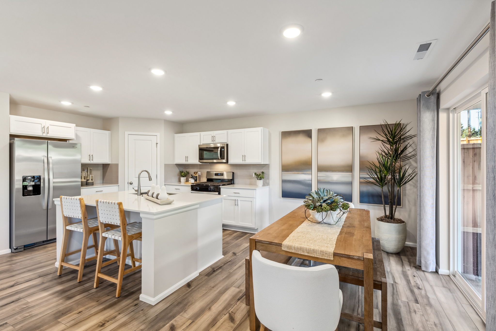 A kitchen with a dining table and white cabinets.