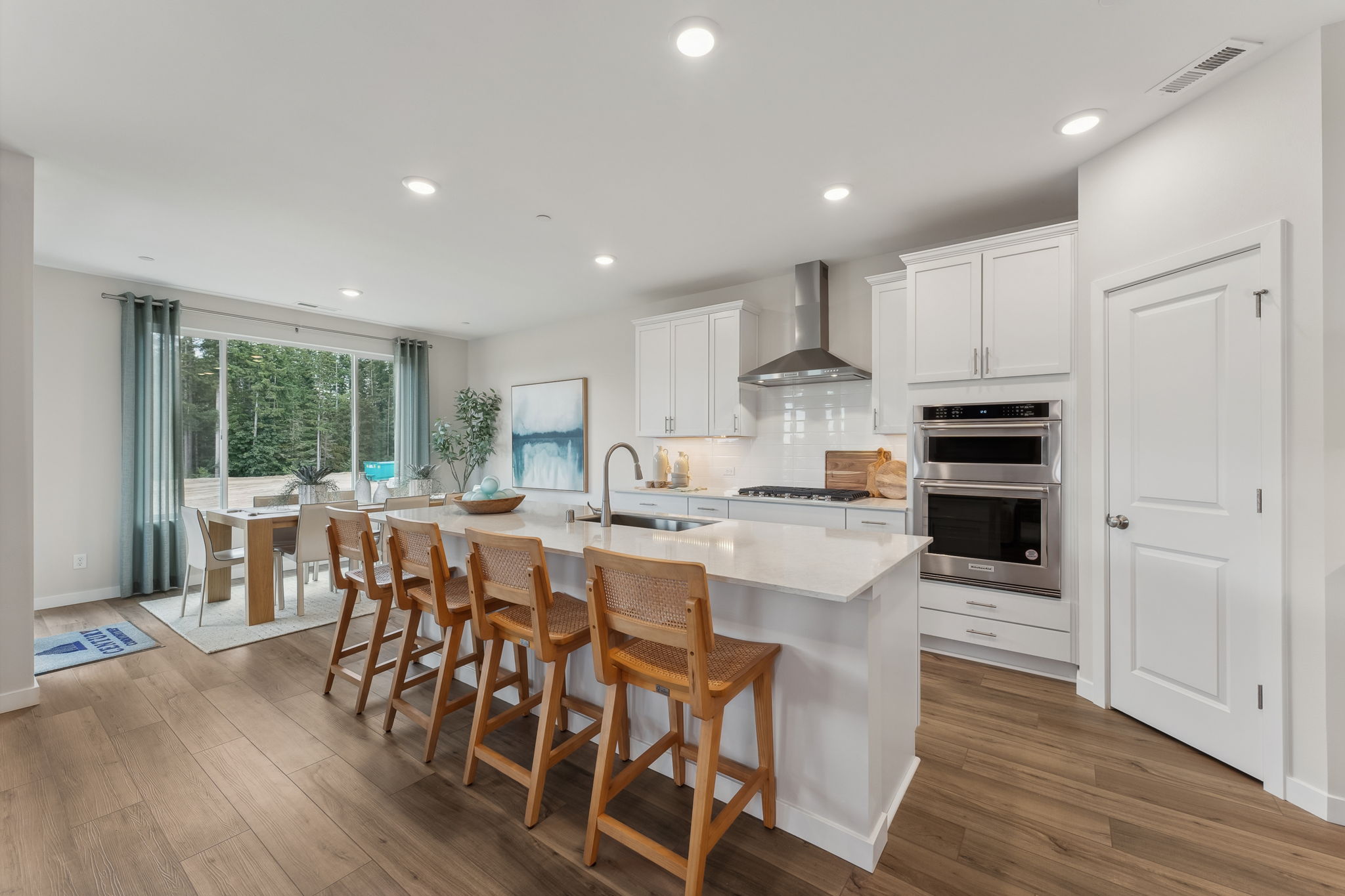 A kitchen with a dining table and chairs.