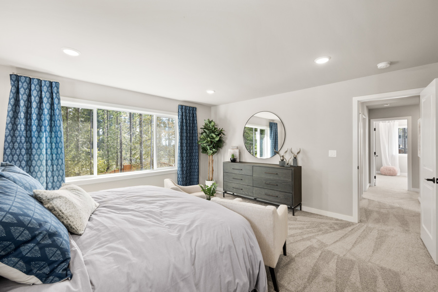 A bedroom with a bed and a mirror.