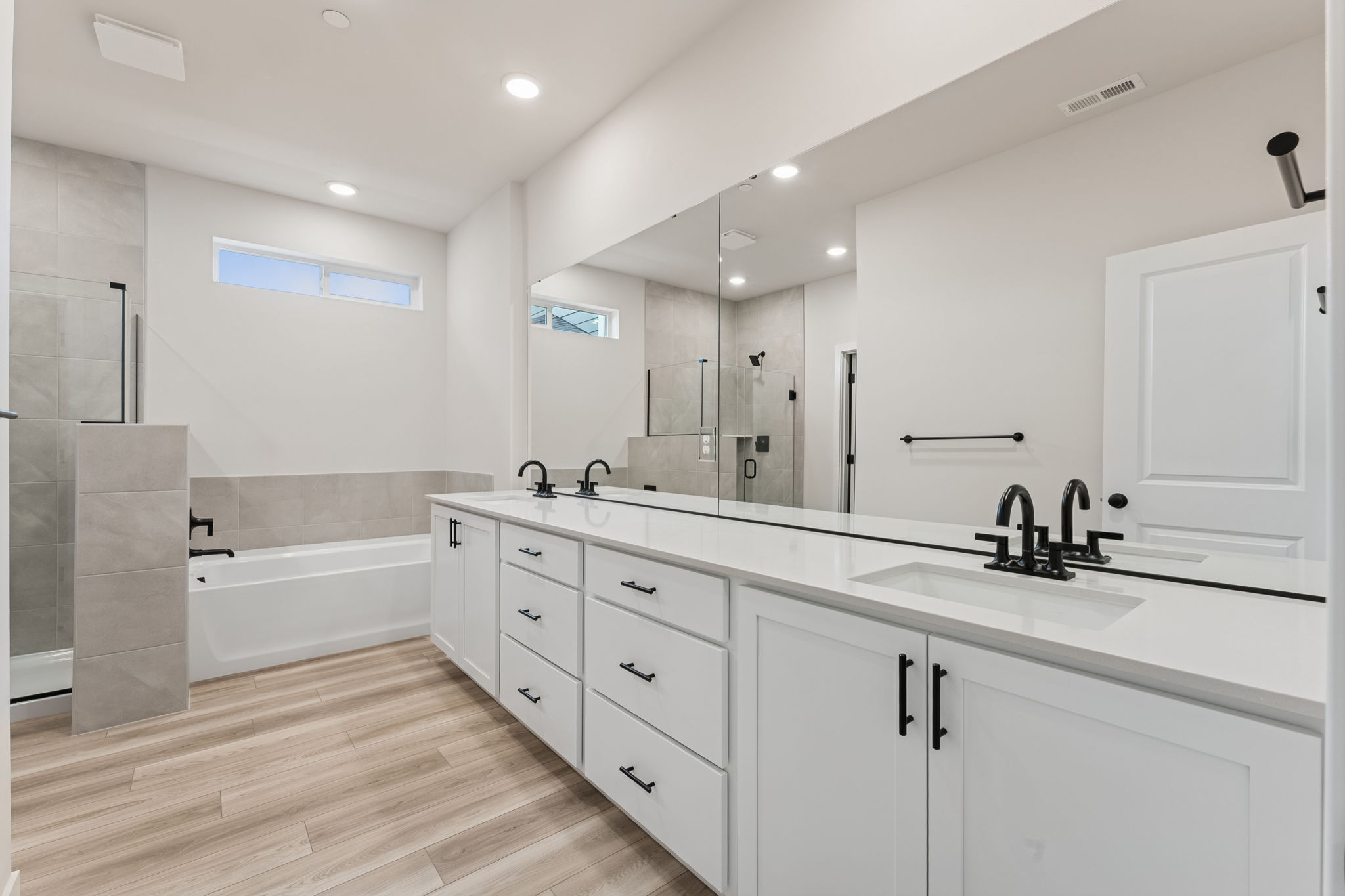 A bathroom with white cabinets.