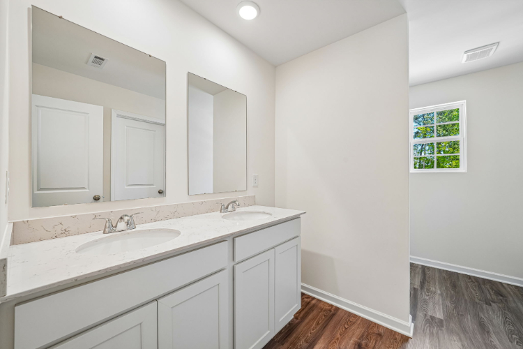 A bathroom with white cabinets.