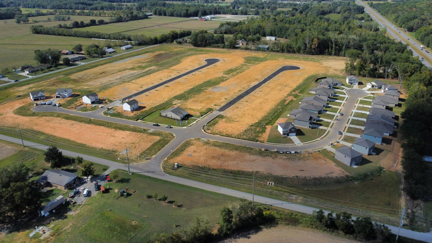 A large field with buildings and trees.