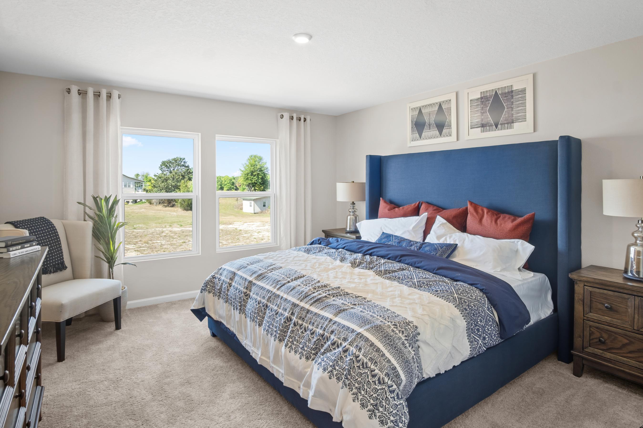 A bedroom with a bed and a chair.