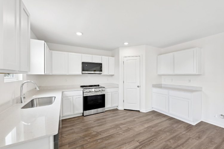 A kitchen with white cabinets.