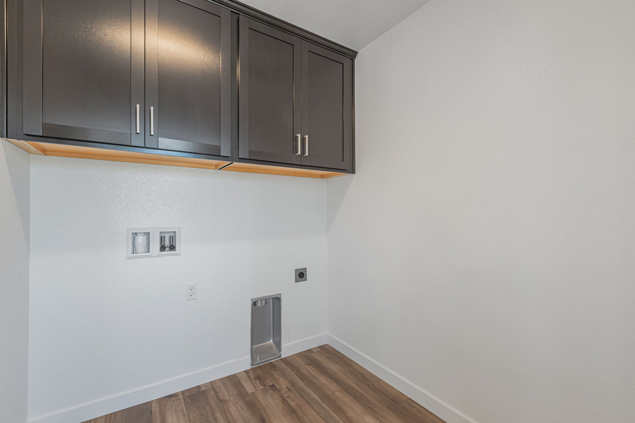 A room with a wood floor and cabinets.